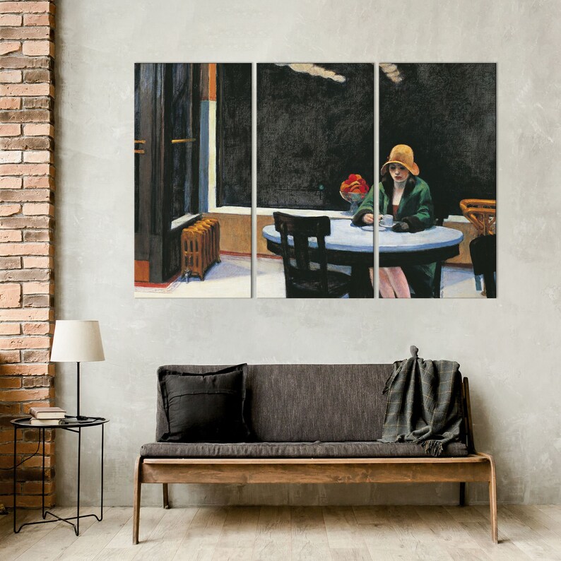 K&ouml;nnte beinhalten: Triptychon-Leinwanddruck von Edward Hoppers Gem&auml;lde "Nighthawks". Das Kunstwerk zeigt eine Frau mit Hut und Mantel, die an einem Tisch in einem Diner sitzt. Die Szene spielt nachts mit dunkler Au&szlig;en- und Innenbeleuchtung.