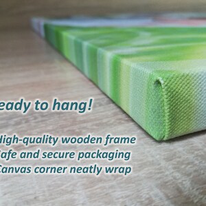 K&ouml;nnte beinhalten: Nahaufnahme eines Leinwanddrucks mit gr&uuml;nem und wei&szlig;em Design. Der Text "Ready to hang!" ist sichtbar, zusammen mit Details &uuml;ber den Holzrahmen, die Verpackung und die Eckverpackung. Die Leinwand ist fertig zum Aufh&auml;ngen.