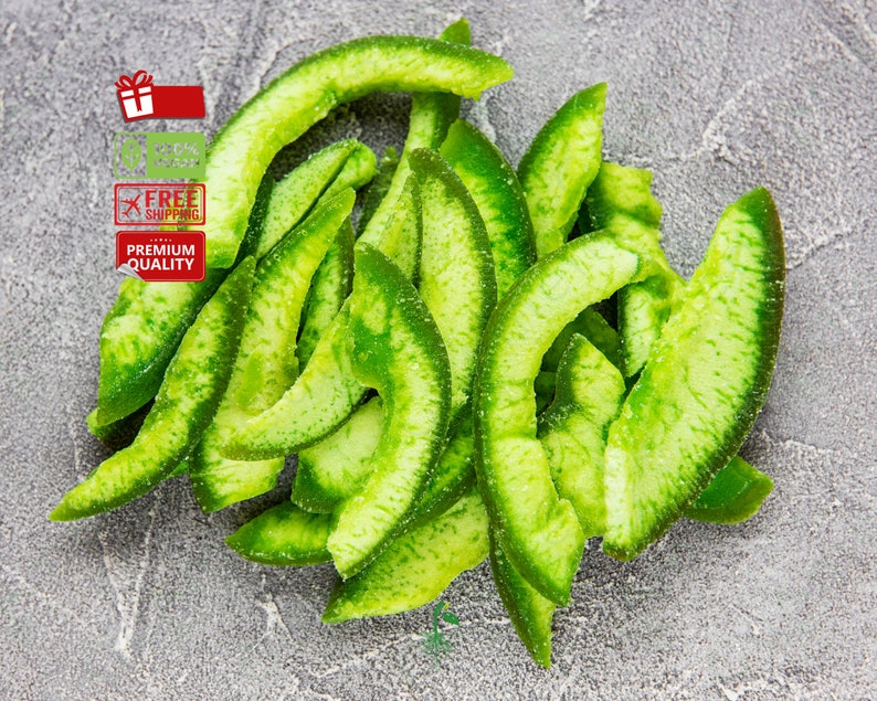 May include: A pile of dried green citrus fruit slices. The slices are arranged in a semi-circle shape, with the tips of the slices pointing towards the center of the circle. The slices are a light green color and have a slightly translucent appearance.