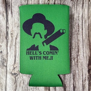 Op de afbeelding: Groene koelbox voor blikjes met een zwart silhouet van een man met een hoed en een geweer. De tekst "Hell's Comin' With Me!!" staat op de koelbox gedrukt.