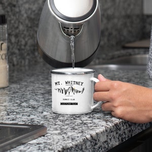 May include: White enamel camping mug with a black and white graphic of a mountain range and the text "MT. WHITNEY CALIFORNIA SUMMIT CLUB CUSTOM TEXT".