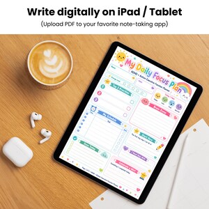 May include: A digital tablet displaying a colourful My Daily Focus Plan ADHD + Autism Executive Function Planner template with sections for priorities, schedule, brain dump, and mood tracking, featuring a sun, rainbow, and cloud graphic design.