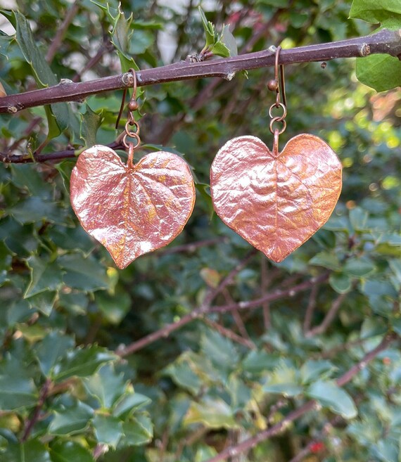Real redbud leaves preserved forever in copper through electroforming — a genuinely 'how did they make this?' piece of wearable nature.