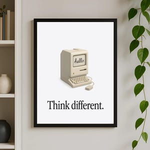 May include: A black framed poster with a white background featuring a vintage-style computer with the word "hello" on the screen. The text "Think different." is below the computer.