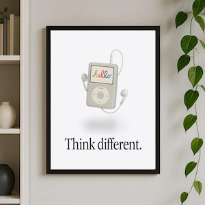 May include: A framed print featuring a gray iPod with white earbuds and the word "hello" in rainbow colors on the screen. Below the iPod, the phrase "Think different" is printed in black.