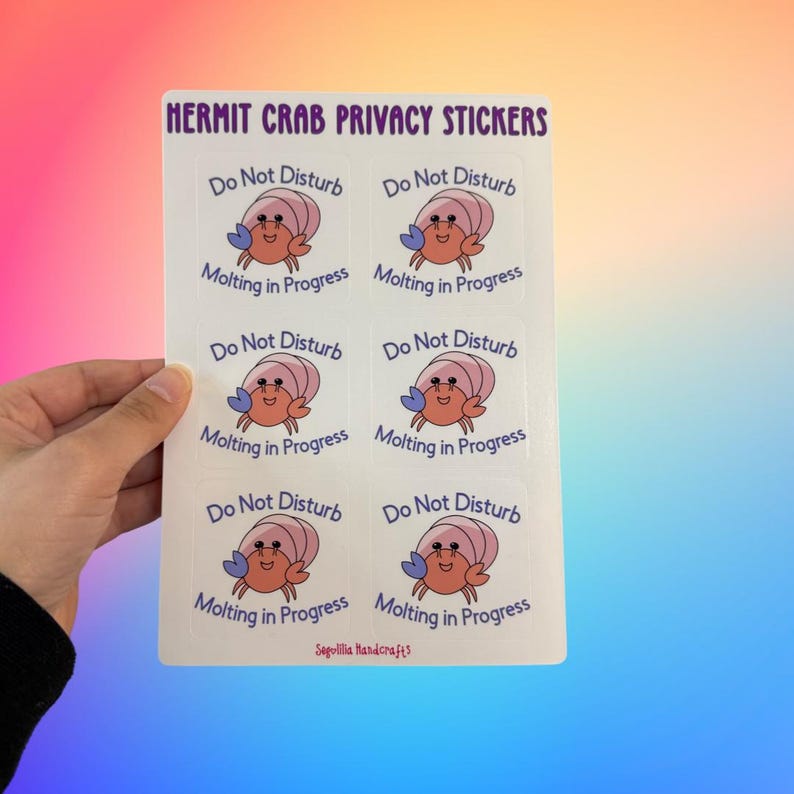 May include: A sheet of 6 white stickers with a cartoon hermit crab on each. The crab is pink and orange with blue eyes. The text on each sticker reads "Do Not Disturb Molting in Progress".