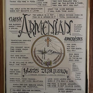 May include: Framed print featuring the word "Armenian" in a decorative font, surrounded by aphorisms and proverbs. The artwork includes a central circular emblem with a cross and mountain scene. The frame is gold-colored.