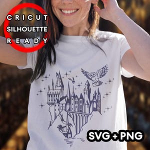 Pode incluir: Camiseta branca com uma ilustração azul escuro de um castelo, uma coruja e estrelas. O texto "CRICUT SILHOUETTE READY" está em um círculo vermelho, e "SVG+PNG" está no canto inferior direito.