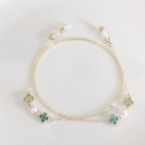 May include: Gold chain glasses retainer with green and white clover charms and white pearl accents.