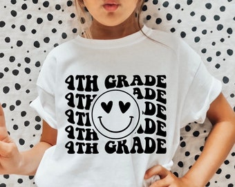 Puede incluir: Una camiseta blanca con texto negro que dice "4th Grade" en una fuente retro. El texto se repite varias veces y una cara sonriente con corazones por ojos está en el centro del diseño.