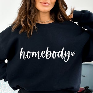 May include: Black sweatshirt with the text "homebody" in white cursive lettering with a small heart symbol.