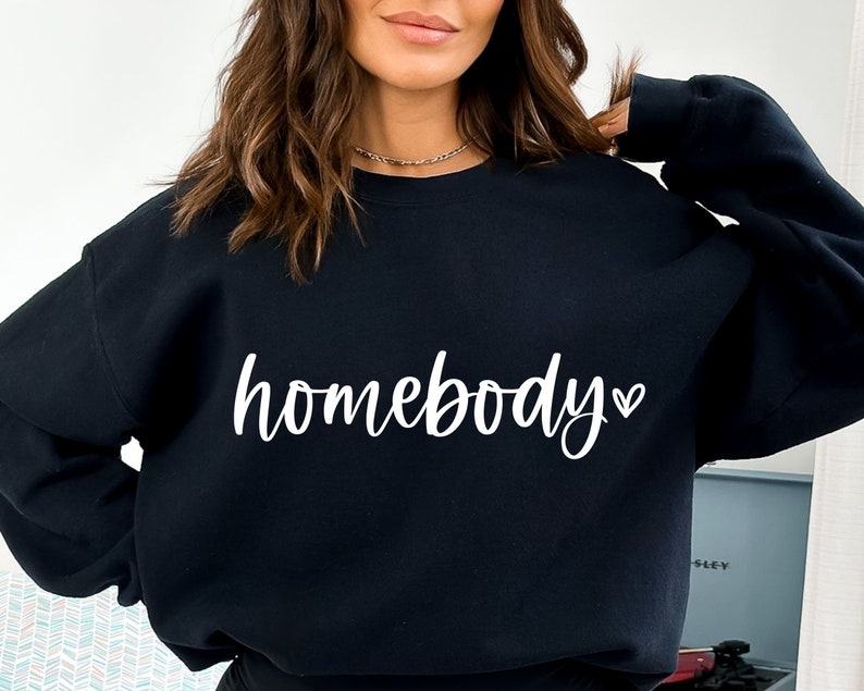 May include: Black sweatshirt with the text "homebody" in white cursive lettering with a small heart symbol.