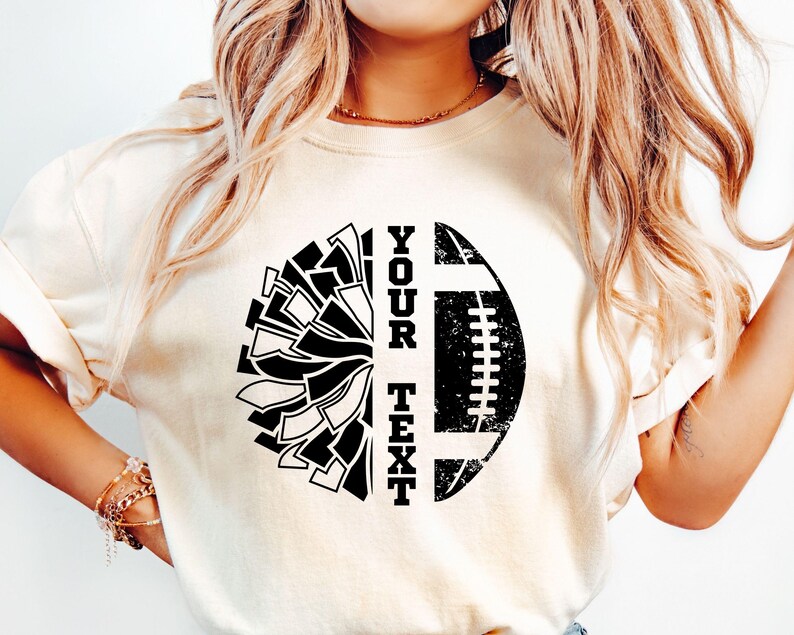 May include: White t-shirt with a black and white graphic design of a football and a cheerleading pom-pom. The text "YOUR TEXT" is printed vertically on the shirt.