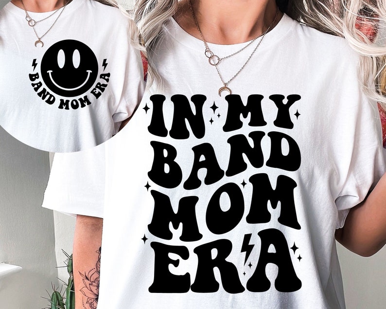 Pu&ograve; includere: Maglietta bianca con testo nero che recita "In My Band Mom Era" in un font retr&ograve;. Un'emoticon con le parole "Band Mom Era" sono stampate sul retro della maglietta.