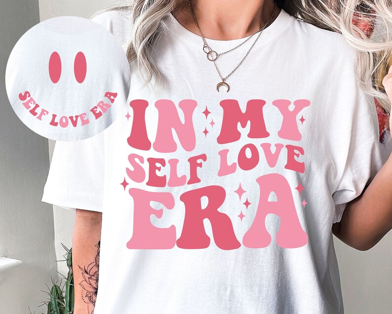 May include: White t-shirt with a pink and red graphic that says "In My Self Love Era".