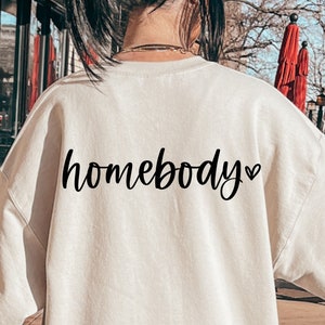 May include: A cream colored sweatshirt with the text "homebody" in black cursive lettering and a small heart symbol.