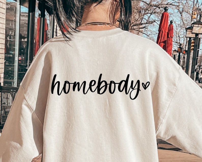 May include: A cream colored sweatshirt with the text "homebody" in black cursive lettering and a small heart symbol.