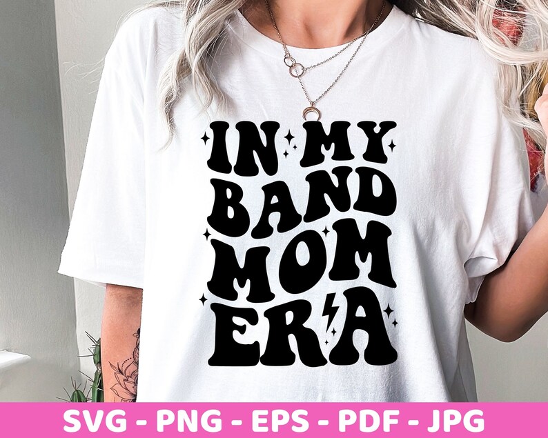 Pu&ograve; includere: Maglietta bianca con testo nero che recita "In My Band Mom Era" in un font retr&ograve;.