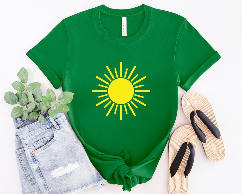 May include: A green t-shirt with a yellow sun graphic. The shirt is made of a soft, comfortable material and has a crew neck.