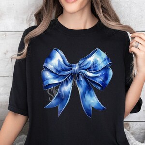 May include: A black t-shirt with a large blue watercolor bow design.