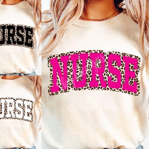 May include: A white t-shirt with the word "NURSE" printed in a pink and leopard print design.
