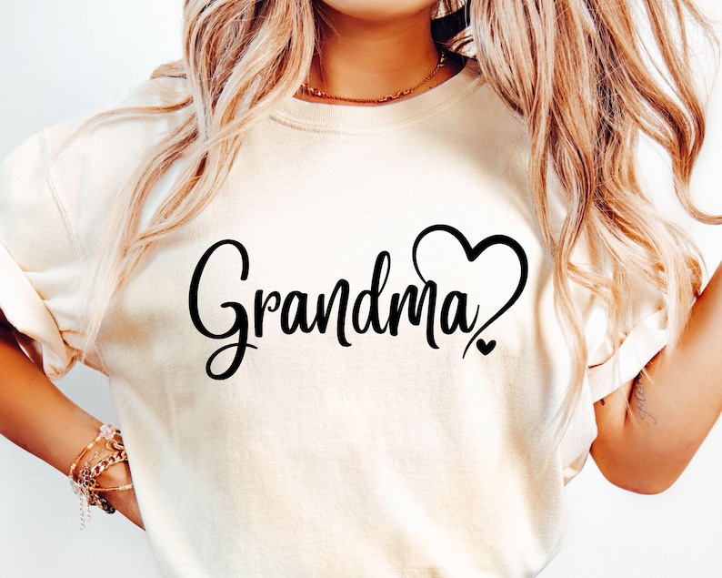 May include: White t-shirt with black text that says "Grandma" with a heart design.