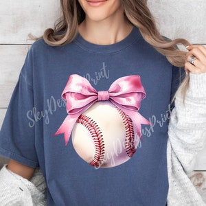 May include: A navy blue t-shirt with a pink bow and a white baseball with red stitching. The text "Sky Designs Print" is visible on the shirt.