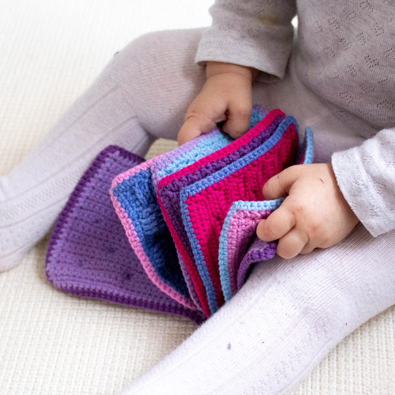 Little one playing with a crochet sensory book made from a downloadable pattern, perfect for interactive play and development.
