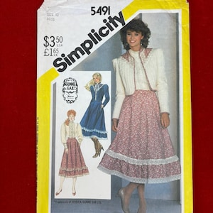 May include: A Simplicity 5491 sewing pattern envelope for a size 12 miss outfit. The cover features illustrations of a two-piece ensemble with a white long-sleeved jacket and a floral print skirt with lace trim, plus a blue dress with lace details.