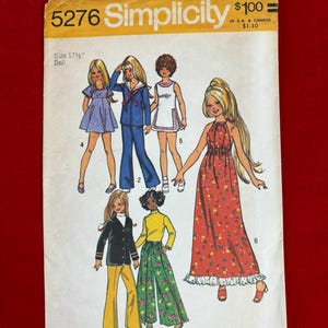 May include: Vintage Simplicity sewing pattern envelope, size 17 1/2" doll. The envelope features illustrations of doll clothing designs, including dresses, a sailor suit, and pantsuits. The envelope is yellow and white with the Simplicity logo.