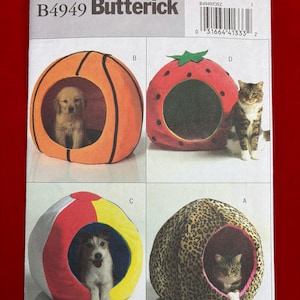 May include: A sewing pattern by Butterick, B4949, featuring four pet bed designs. The beds are shaped like a basketball, strawberry, beach ball, and a leopard print cave. Each bed has an opening for a small dog or cat.