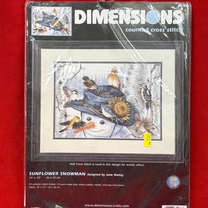 May include: A Dimensions counted cross stitch kit titled Sunflower Snowman, designed by Jane Maday. The package features a snowman wearing a blue hat adorned with sunflowers and birds, measuring 14 inches by 10 inches on 14 count white Aida.