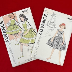 May include: Two vintage sewing pattern envelopes on a red background. One features a green dress design, the other a plaid dress. The patterns are labeled "Advance" and include the numbers 9477 and 9408.