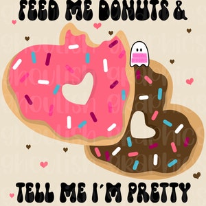 May include: A pink and brown heart-shaped donut with sprinkles and a ghost graphic. The text "FEED ME DONUTS & TELL ME I'M PRETTY" is written in black.