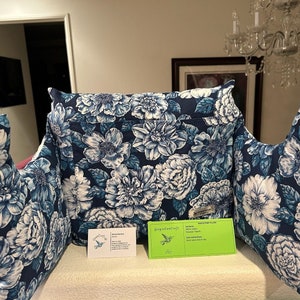May include: Three blue and white floral patterned pillows with a white card with a hummingbird graphic and text that reads "GoogleCrafts".