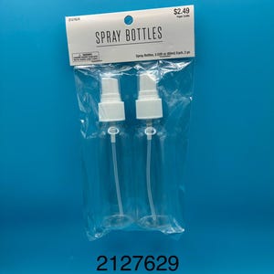 May include: Two clear plastic spray bottles with white pump sprayers, packaged in a transparent plastic bag with a header card labeled SPRAY BOTTLES and Spray Bottles, 2.03 fl oz (60ml) Each, 2 pc. The header also includes a warning label.