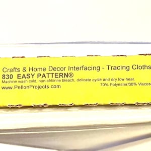 May include: A roll of white fabric with a yellow label. The label reads "Crafts & Home Decor Interfacing - Tracing Cloths" and "830 EASY PATTERN". The roll is 45 inches wide and 28 yards long. The fabric is made in the USA.