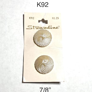 May include: Two off-white, spiral-design buttons, 7/8 inch in diameter, on a Streamline brand card. The card has the text "K92" and "$1.25".