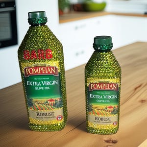 May include: Two bottles of Pompeian Extra Virgin Olive Oil, embellished with sparkling green and gold accents. The labels read "Extra Virgin Olive Oil" and "Robust". The bottles are on a wooden surface.