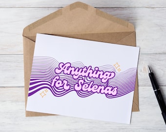 May include: A white card with purple and pink text that reads "Anything for Selenas" on a white background with purple wavy lines and gold stars. The card is sitting on a brown envelope.