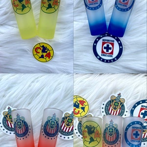 Puede incluir: Seis vasos de chupito escarchados con diferentes logotipos de equipo. Los logotipos incluyen Club Deportivo Guadalajara, Cruz Azul y Club Am&eacute;rica. Los vasos de chupito est&aacute;n sobre una superficie blanca y peluda.
