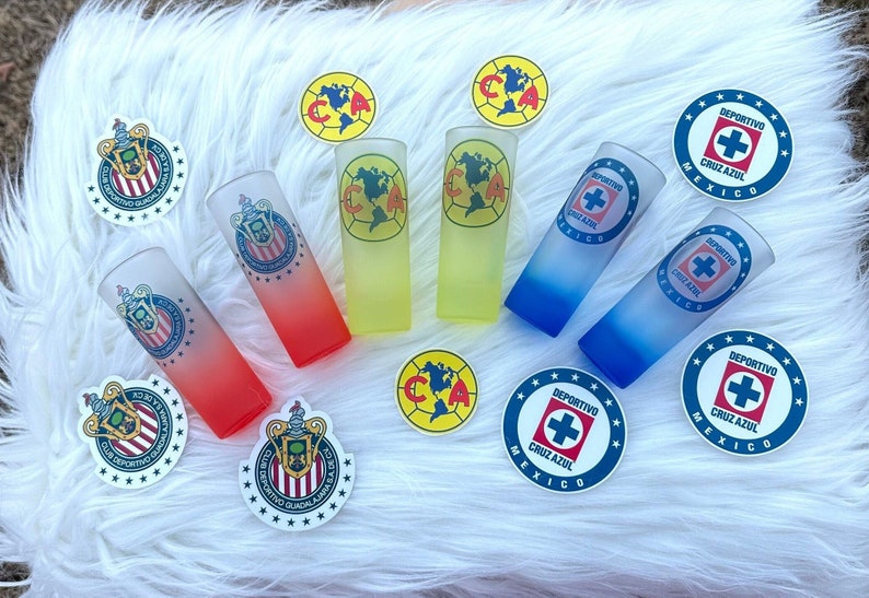 Puede incluir: Un set de seis vasos de chupito con diferentes logotipos de equipo. Los vasos son esmerilados y tienen un efecto de degradado de color. Los logotipos incluyen el Club Deportivo Guadalajara, el Club Am&eacute;rica y el Deportivo Cruz Azul.