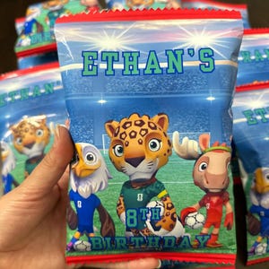 May include: A rectangular snack bag with a blue stadium background featuring cartoon animal football players, including a leopard, an eagle, and a moose. The text reads ETHAN'S 8TH BIRTHDAY in blue and green lettering against the stadium scene.