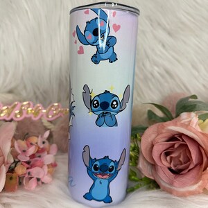 Puede incluir: Un vaso de acero inoxidable azul y blanco con un dise&ntilde;o degradado que presenta varias im&aacute;genes de Stitch de Lilo & Stitch. El vaso tiene una tapa transparente.