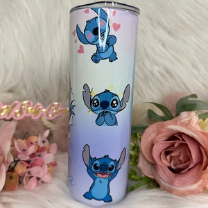 May include: A blue and white stainless steel tumbler with a gradient design featuring multiple images of Stitch from Lilo & Stitch. The tumbler has a clear lid.