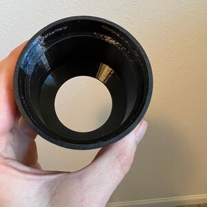 Puede incluir: Un embudo de pl&aacute;stico negro con un interior liso y redondeado. El embudo est&aacute; dise&ntilde;ado para guiar l&iacute;quidos hacia una abertura m&aacute;s peque&ntilde;a.