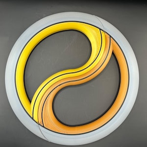 May include: A white, yellow, and orange yin yang symbol with black lines. The symbol is made of three concentric circles.