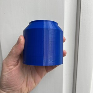 Puede incluir: Un recipiente cil&iacute;ndrico azul impreso en 3D con una superficie lisa y ligeramente texturizada.