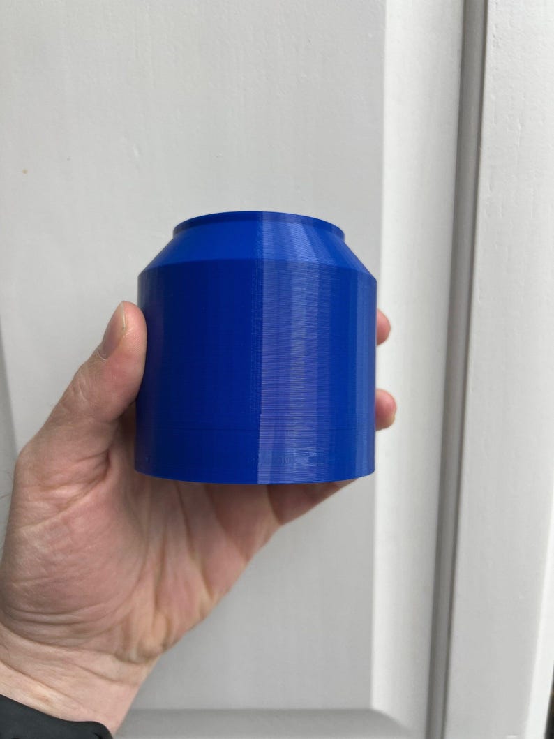 Puede incluir: Un recipiente cil&iacute;ndrico azul impreso en 3D con una superficie lisa y ligeramente texturizada.