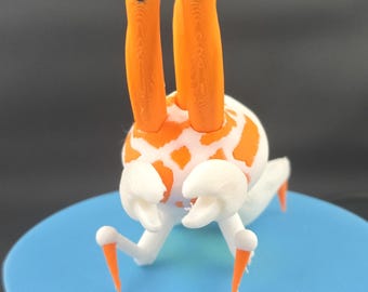 May include: A small, three-dimensional printed figurine of a creature with a white body featuring orange spots. It has two long, upright orange antennae with black tips, two white pincer-like claws, and four thin, white legs with orange pointed ends.